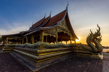 Obraz premium Background of the tourist attraction Wat Sirindhorn Wararam or the famous glowing temple in Thailand. Ubon Ratchathani is adjacent to Laos. Tourists always like to come to see the beauty at night.