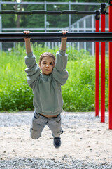 Obraz premium Young girl practicing on horizontal bars outdoors in recreational park area