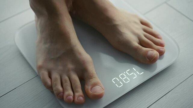 A man stands on a scale and measures his weight.
A man measures his weight on a scale.
Libra, weight, man, legs, heavy, light