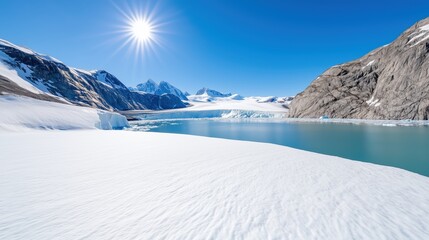 Glacier landscape with turquoise water and snow-capped mountains under a bright sun and blue sky showcasing a cold and remote environment
