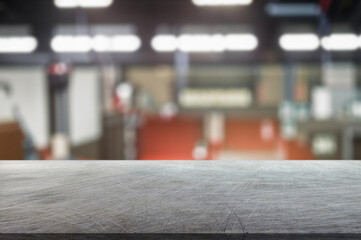 blurred background of factory and empty steel tabletop in foreground. Business presentation