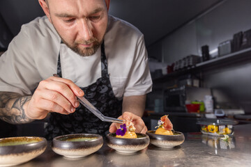 Professional chef garnishing small appetizers