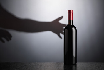 Bottle of red wine on a black table.