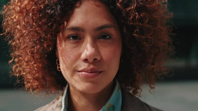 Confident young businesswoman stands in the city, exuding professionalism and success in a corporate setting. A diverse and inclusive workplace with modern business attire.