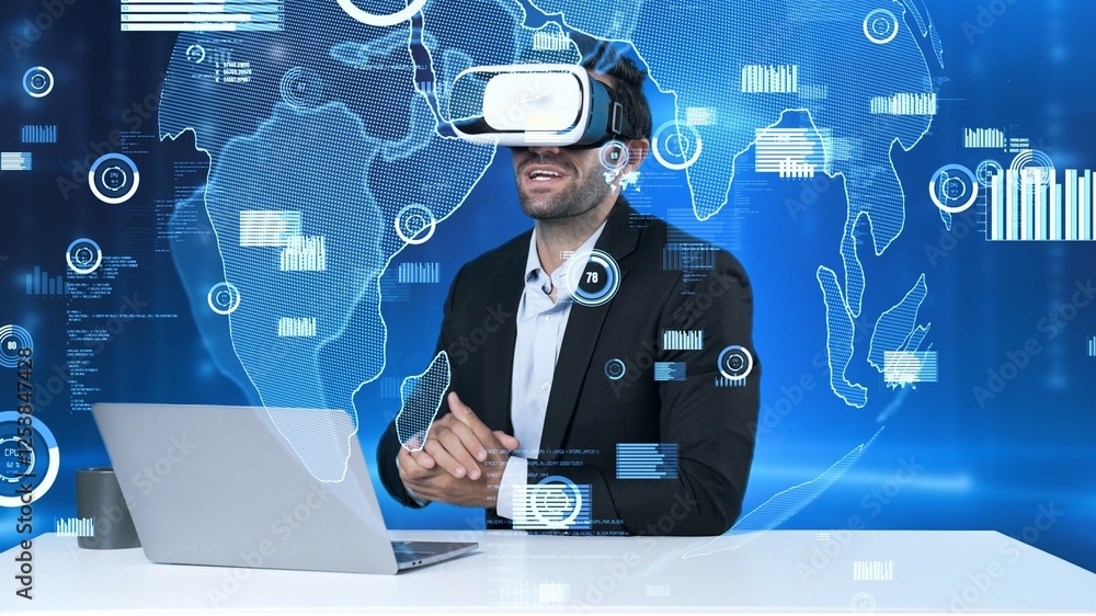 Poster manager sharing marketing idea while sitting at table with laptop while wearing virtual reality glas