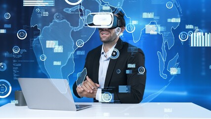 Manager sharing marketing idea while sitting at table with laptop while wearing virtual reality glasses. Investor checking at financial chart floating while connecting with global network. Apparatus.
