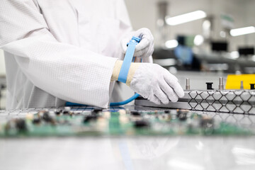 Working in electronics factory. Worker putting on anti static wristband or grounding bracelet while...