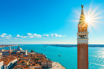 Fototapeta premium Stunning view of San Marco Square with Campanile in Venice, Italy, showcasing vibrant blue sky and shimmering water. perfect blend of architecture and nature