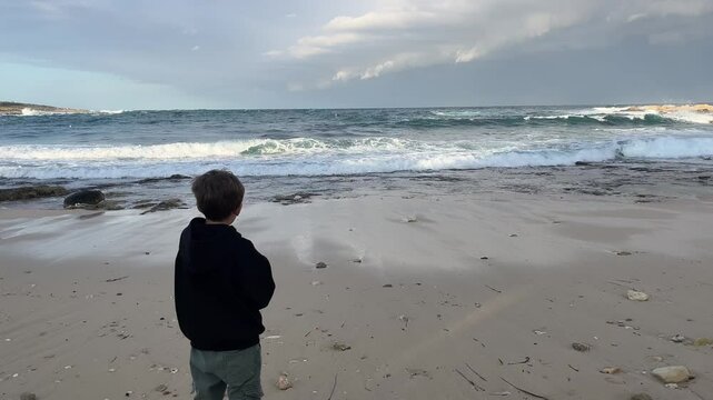 Silhouette of a boy on the seashore.