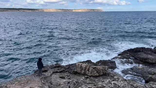 Silhouette of a boy on the seashore.