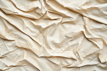 Obraz premium Crumpled beige fabric texture with soft folds and creases, ideal for backgrounds