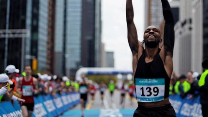 Overjoyed male marathon runner, wearing bib number 139, crosses the finish line with arms outstretched, his face beaming with happiness and accomplishment, captured in a slow motion montage