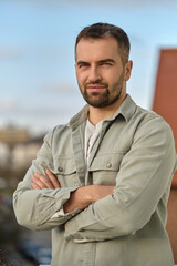 Portrait of a young happy causal man outside looking at the camera.
