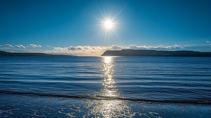 Serene Coastal Scene Sunlit Ocean And Distant Mountains