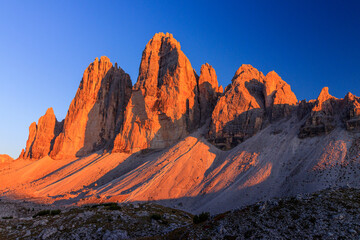 north side of Tre Cime di Lavaredo in the sextner dolomites during sunset with warm golden light...