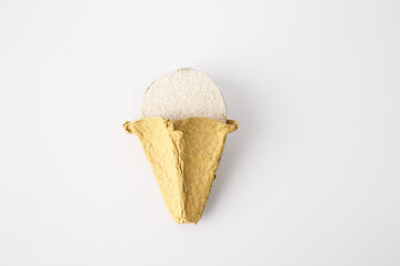 Handcrafted ice cream cone made from molded paper pulp, showcasing texture and fibrous material. DIY project for kids, recycling concept, educational content, and eco-conscious businesses