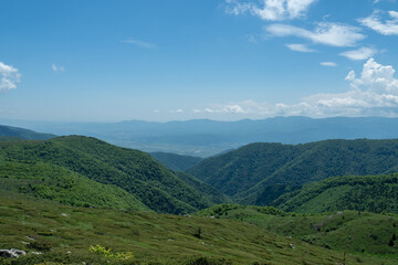 Scenic mountain landscape with green hills under a blue sky, showcasing nature's beauty and tranquility. Ideal for themes of outdoor exploration and vibrant springtime scenery - Bulgaria, Europe