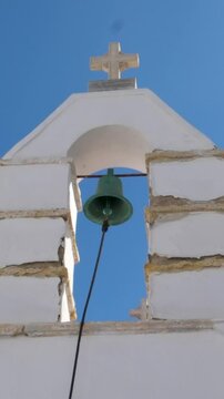 Church bell ringing belfry bright white stone with cross on top, has electrical mechanism instead of a rope. High quality 4k footage