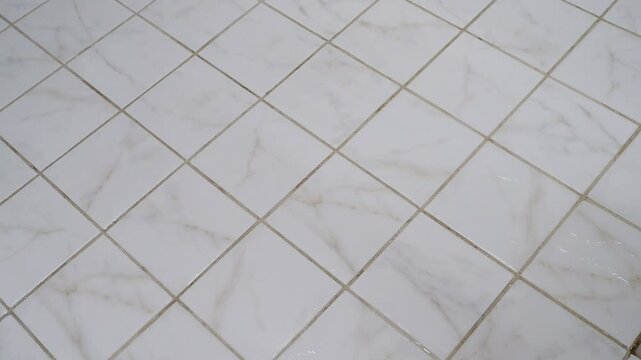 The master cleans old floor and floor tiles. Preparing floor for new floor tiles. The master cleans Small-format tiles from dirt. Concept cleaning house, office, public space. Cleanliness, freshness