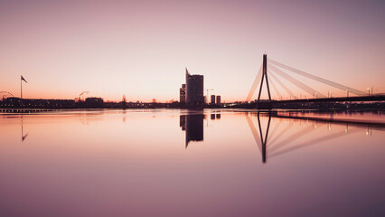 Fototapeta premium Sunset Panoramic view of Riga city with reflection from Daugava river bank.