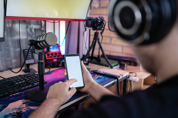 Gamer using smartphone with white screen in streaming setup