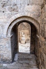 View from above of an ancient stone staircase under medieval stone arches