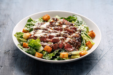 Beef steak Caesar salad with croutons, parmesan cheese and lettuce. Healthy food