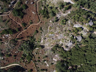 Top-down aerial view of rugged terrain in Ponteareas, featuring winding dirt paths, rocky formations, and patches of dense vegetation, providing a unique perspective on the natural landscape

