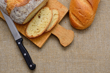 Fresh bread loaf with a knife on a cutting board