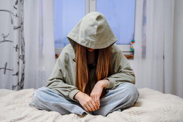 Depressed teenage girl, withdrawn posture. The concept of problems and loneliness in children.