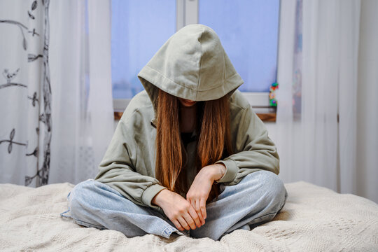 Depressed teenage girl, withdrawn posture. The concept of problems and loneliness in children.