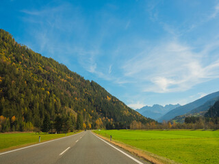 bright autumn landscape, view of the Austrian Alps. road to Italy on sunny day.