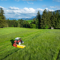 Grünfuttergewinnung im Allgäu - Traktor mit Mähwerk beim Gras mähen, Luftaufnahme. © Countrypixel