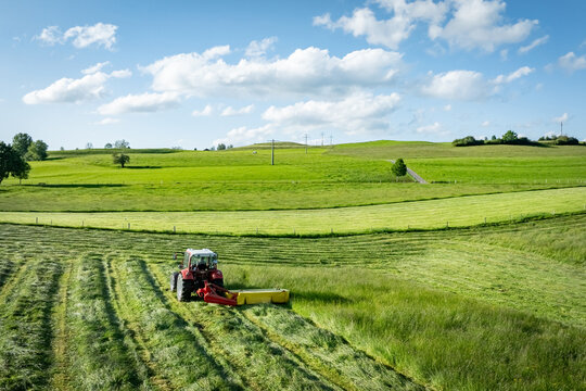 Gr&uuml;nfuttergewinnung im Allg&auml;u - Traktor mit M&auml;hwerk  beim Gras m&auml;hen, Luftaufnahme.