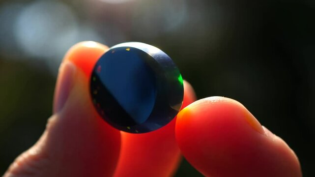 Black opal Gemstone in Hand