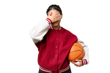 Young Uruguayan woman playing basketball over isolated wall  over isolated chroma key background covering eyes by hands. Do not want to see something