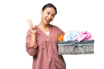 Young Uruguayan woman holding a clothes basket over isolated chroma key background smiling and...