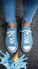 A pair of blue sustainable sneakers stands over a melting ice cream cone on asphalt, symbolizing the urgent need for climate action and youth engagement in eco activism
