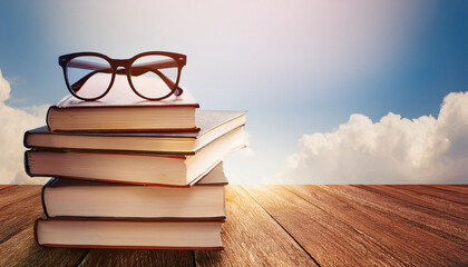 stacked textbooks and glasses on timber floor