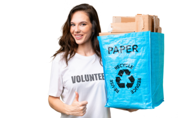 Young caucasian woman holding a recycling bag full of paper to recycle over isolated background with thumbs up because something good has happened