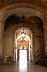 A passageway under stone arches in the historic city of Syracuse, Italy
