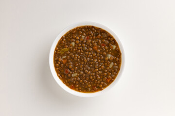 A top view of a round white bowl filled with lentil soup, set against a white background. Simple, clean design, perfect for food styling, product mockups, or promotional use.
