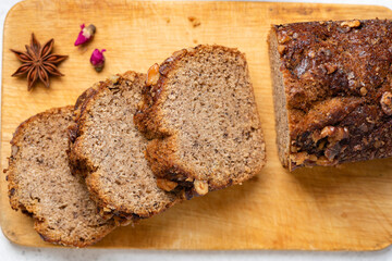 Whole wheat banana bread with cinnamon and walnuts cut into thick slices, closeup view