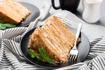 Slice Of Layered Honey Cake On Stylish Black Plate, Closeup View, Sweet Dessert Food