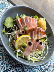 sashimi platter with salmon and tuna, beautifully garnished with caviar, lemon, and a fresh side salad.