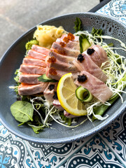 sashimi platter with salmon and tuna, beautifully garnished with caviar, lemon, and a fresh side salad.