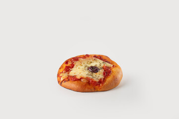 A small, golden pizzetta topped with a black olive, perfectly baked to a crisp, offering a savory Italian snack, set against a clean white background.