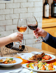 Beautiful couple with glasses of red wine in restaurant