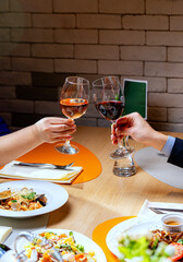 Beautiful couple with glasses of red wine in restaurant