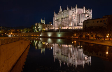 Palma Cathedral Catedral de Santa María de Palma de Mallorca - one of the highest Gothic choir in the world 44m with reflection in park pond during sunset evening time blue hours © Soloviova Liudmyla